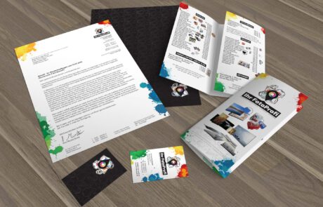 Bild: 3D-Rendering der gedruckten Materialien des Corporate Designs von "Ihr FotoProfi". Darunter ein Brief im Briefpapierdesign mit Mustertext, ein weiteres Blatt des individuellen Briefpapiers mit vollflächig bedruckter Briefrückseite, zwei Flyer die das Angebot und die Preisliste zugefaltet und offen zeigen, sowie zwei Visitenkarten in Vor- und Rückseite.