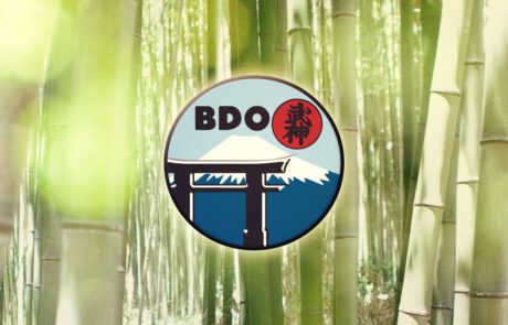 Bild: Ein Headerbild, dass das Kampfsport-Dojo Logo in Farbe vor einem vollfarbigen Hintergrund aus Bambusstreben im Sonnenlicht zeigt.